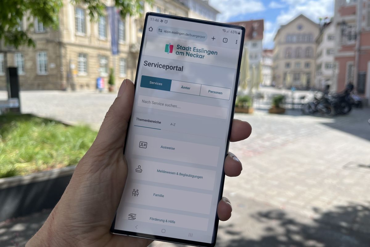 Das Serviceportal auf einem Smartphone - im Hintergrund der Rathausplatz Esslingen.