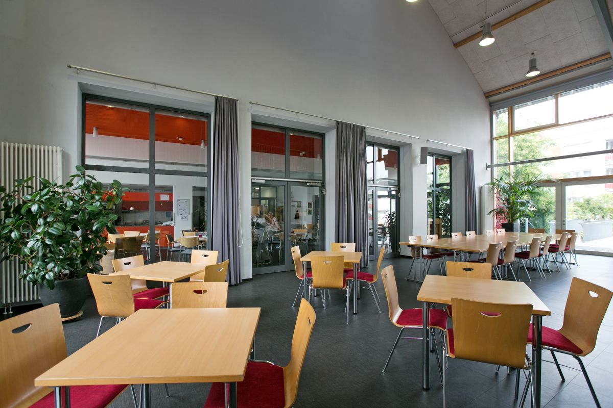 Blick in den Saal mit Tischen und Stühlen. 