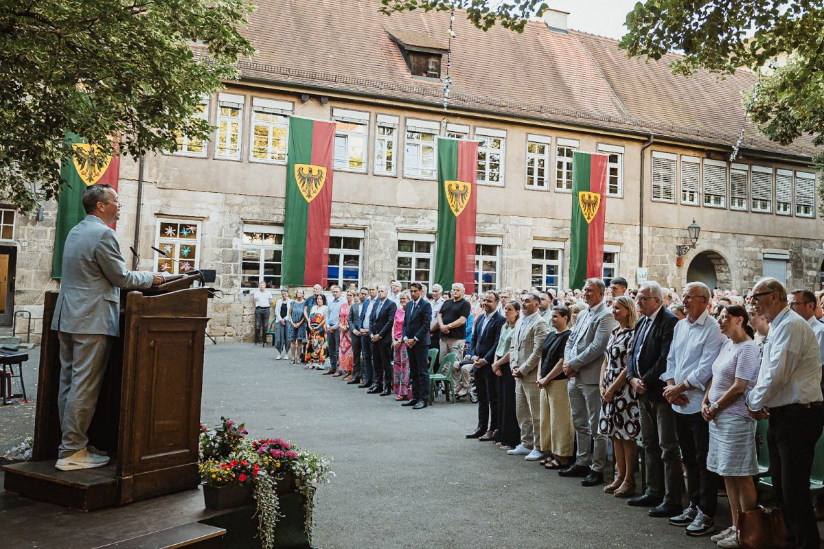 Die Mitglieder des Gemeinderats und die Bürgerstaft stehen während der Verpflichtung auf