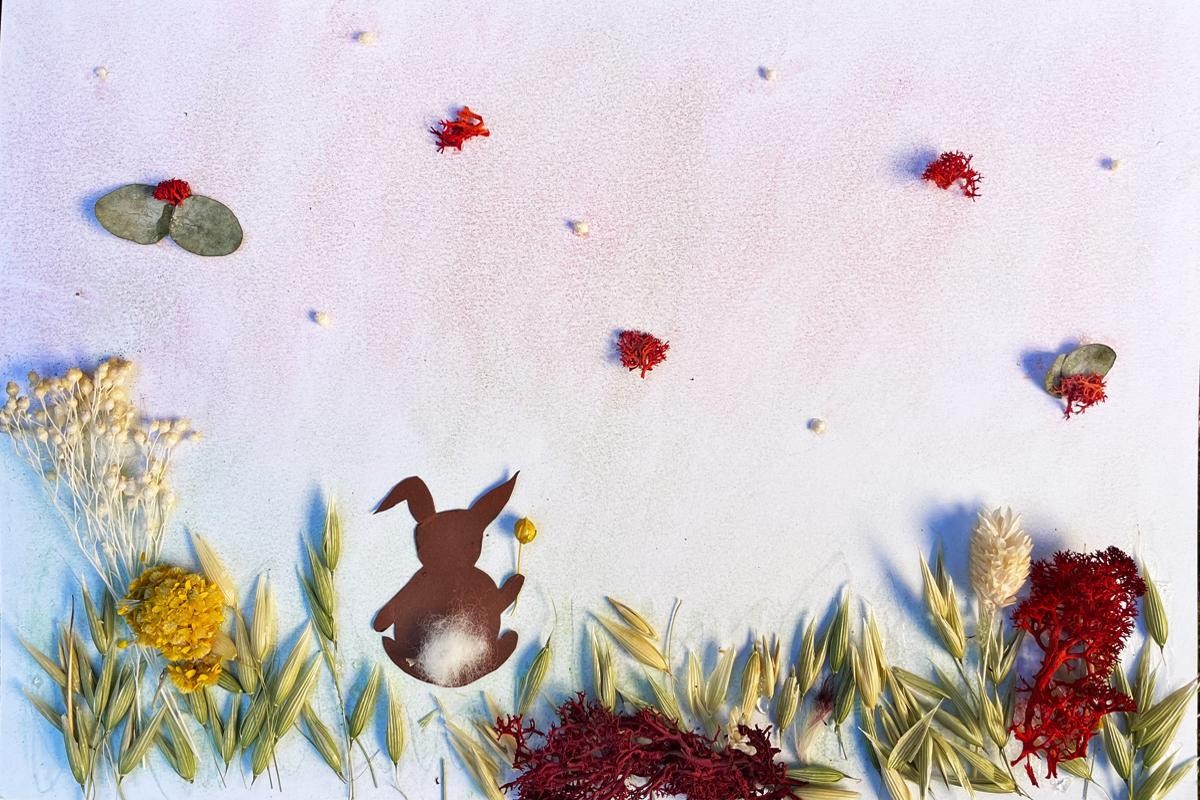 Strohblumenbild Hasenwiese ©Städtische Museen Esslingen Gebasteltes Bild: Eine Blumenwiese aus Strohblumen und getrockneten Gräsern, auf denen aus Karton ausgeschnittene Hasen sitzen.