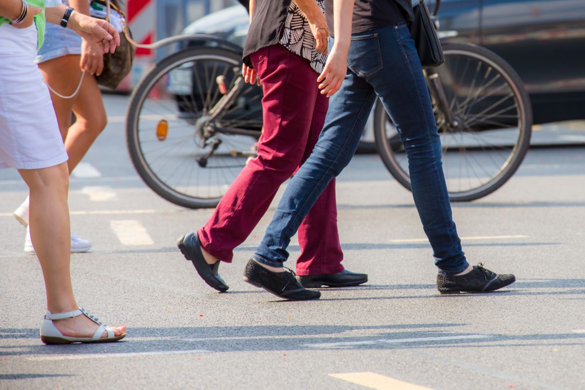 Fußgänger, Radfahrer und Autos auf einer Kreuzung.