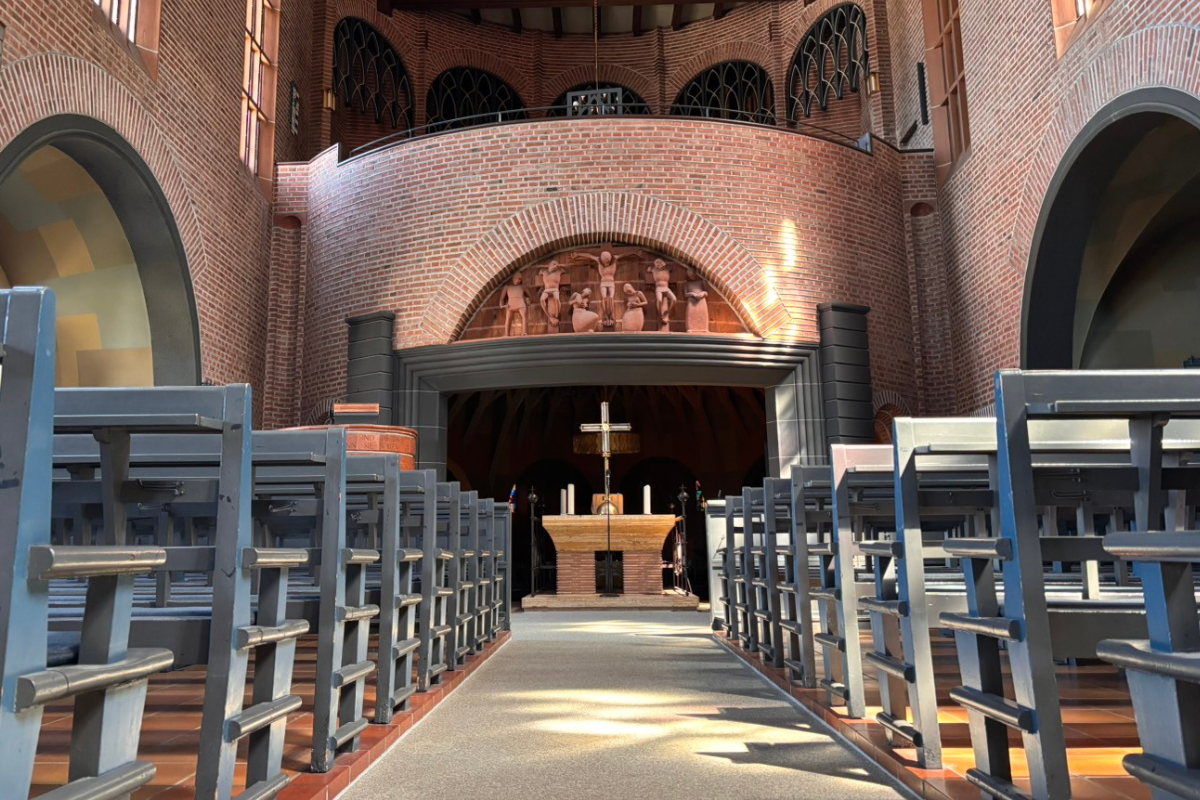 Südkirche Blick auf den Altar, rechts und links blaue Bänke.