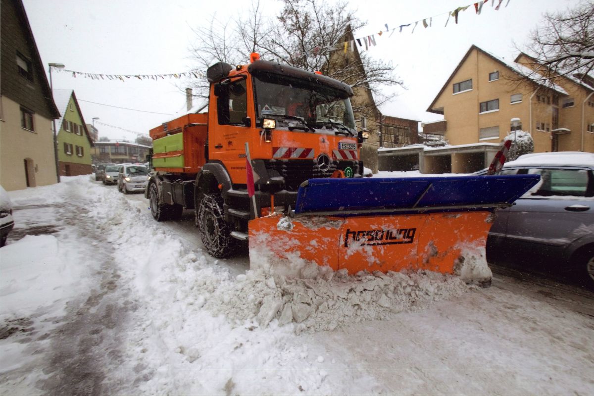 Räumfahrzeug schiebt Schnee auf der Straße zur Seite