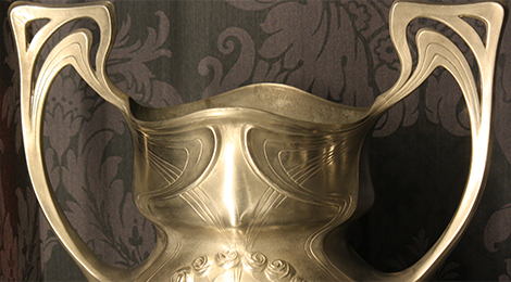 Detailfoto einer Jugendstil-Vase mit zwei großen geschwungenen Henkeln.