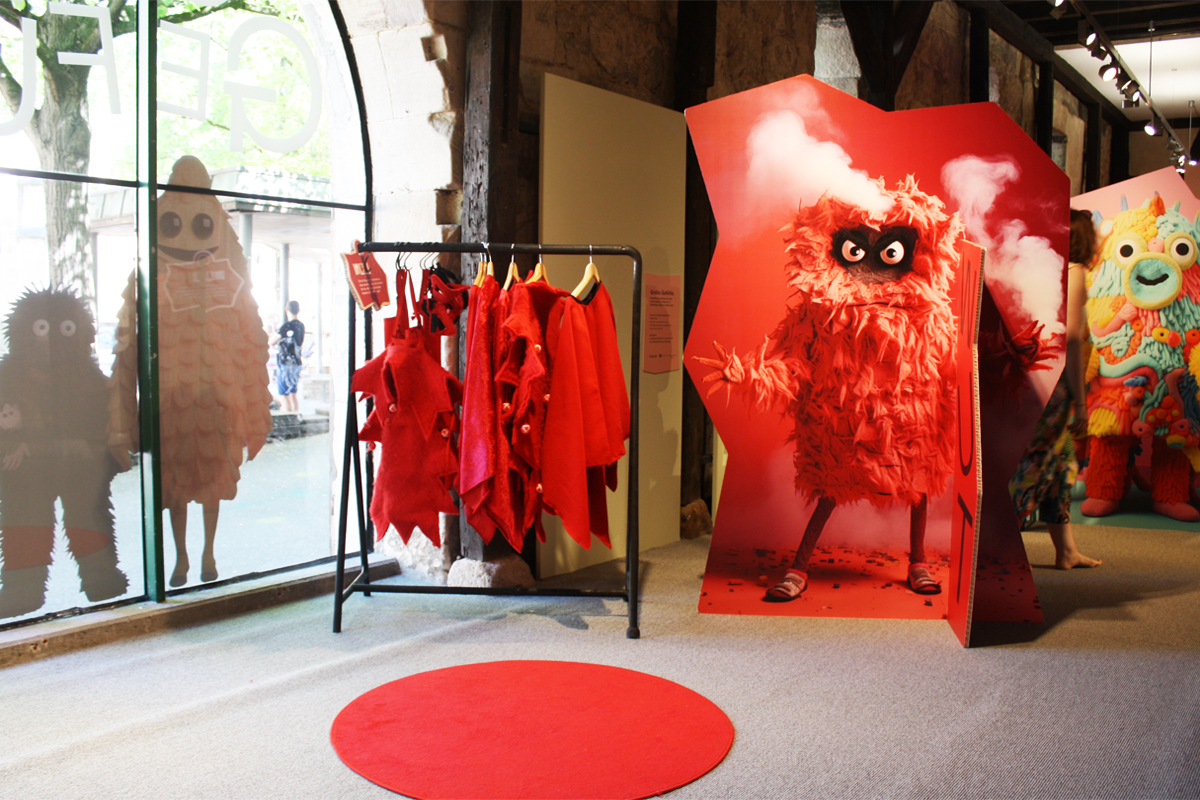 Ausstellungsraum mit einem Kleiderständer und einer Figur, die wütend wirkt.