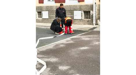 Auf der Straße: Ein Schlauch wird an einen Hydranten angeschlossen.
