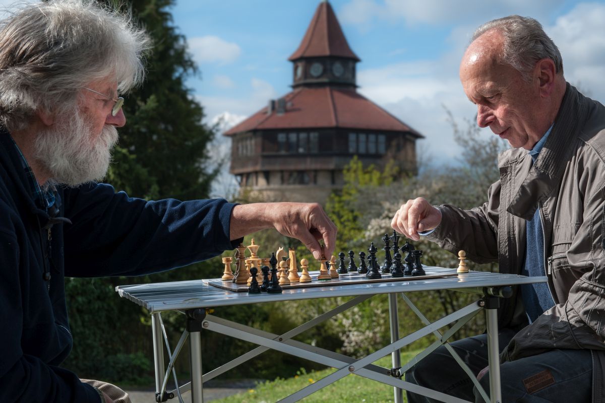Zwei ältere Herren beim Schachspiel, im Hintergrund der Dicke Turm Esslingen.