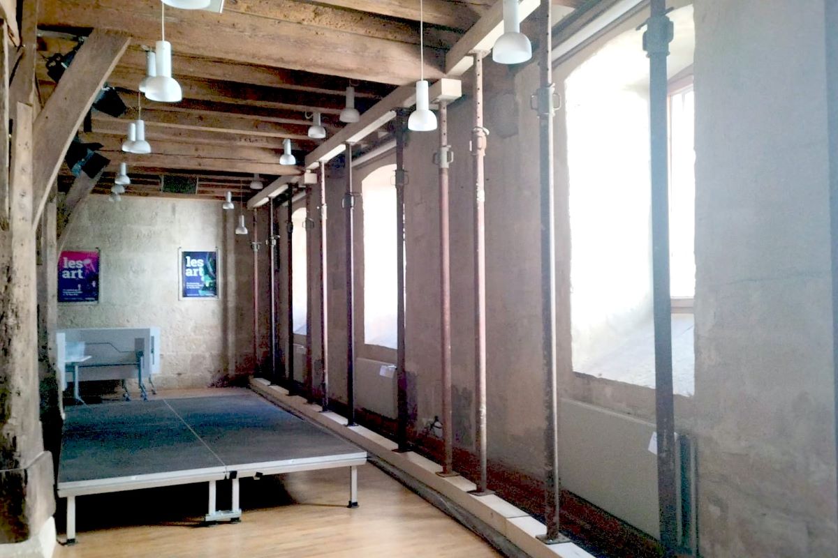 Kutschersaal mit Sprießung Blick in einen Raum mit Holzdecke. An der Fensterseite sind einige Stahlstützen aufgestellt.
