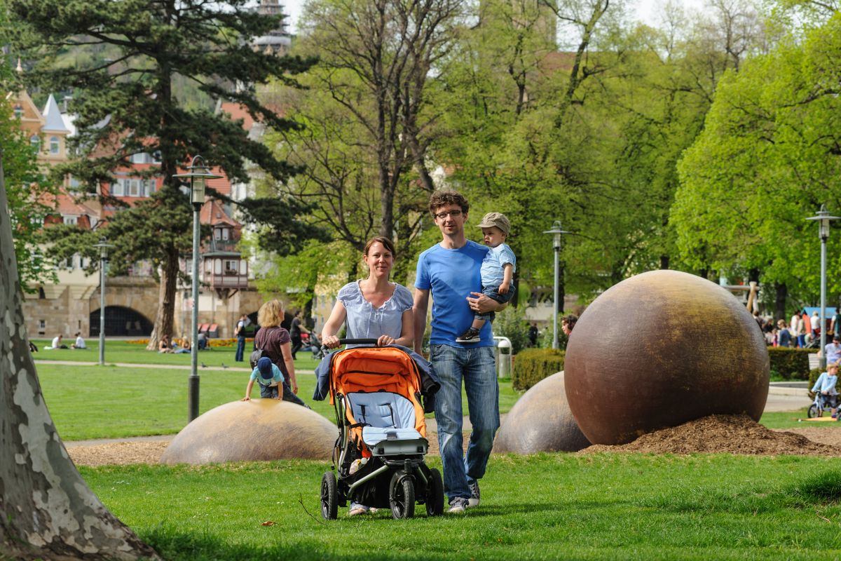 Junge Familie mit Kinderwagen im Stadtpark Maille