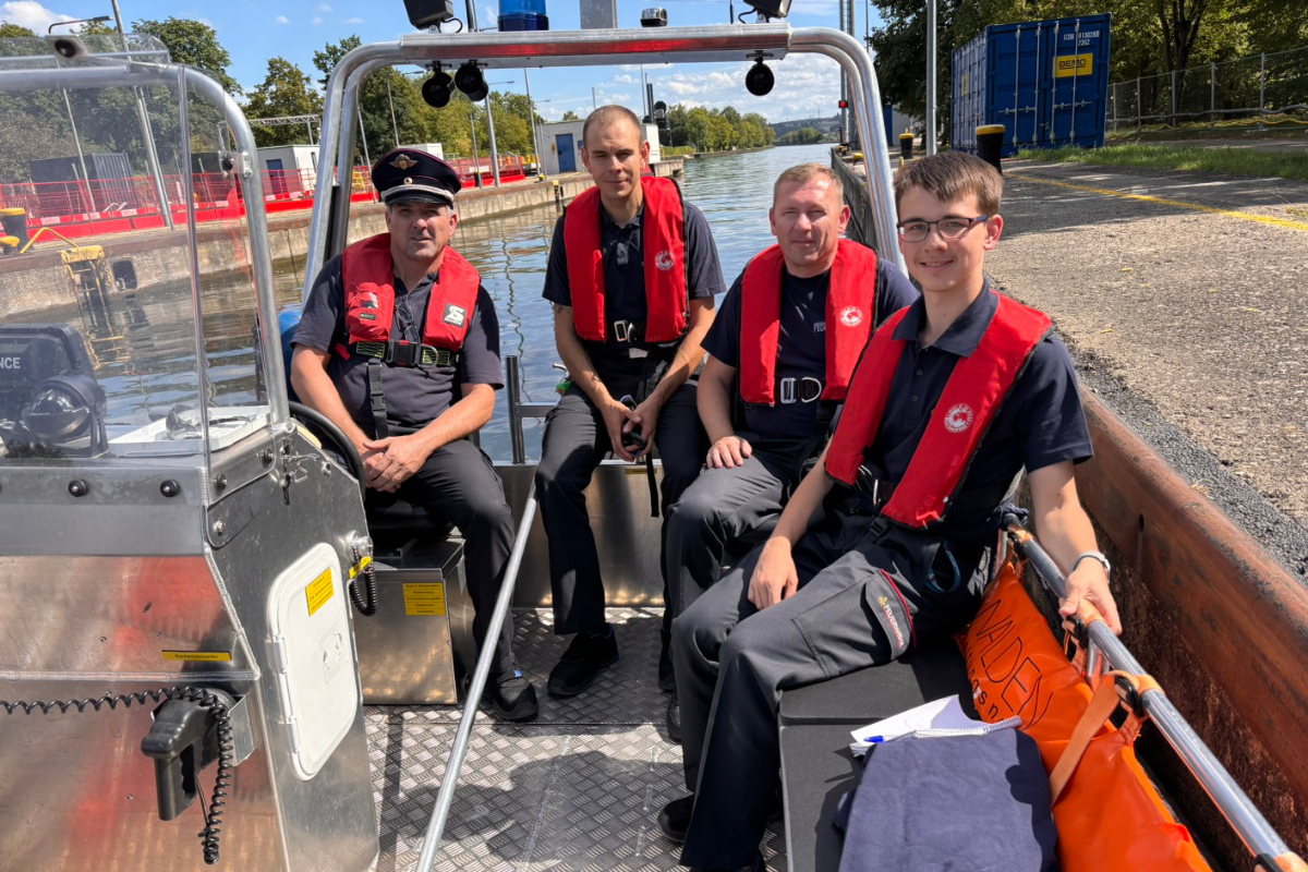 Team Gruppenbild mit den vier Feuerwehrmännern im Boot.