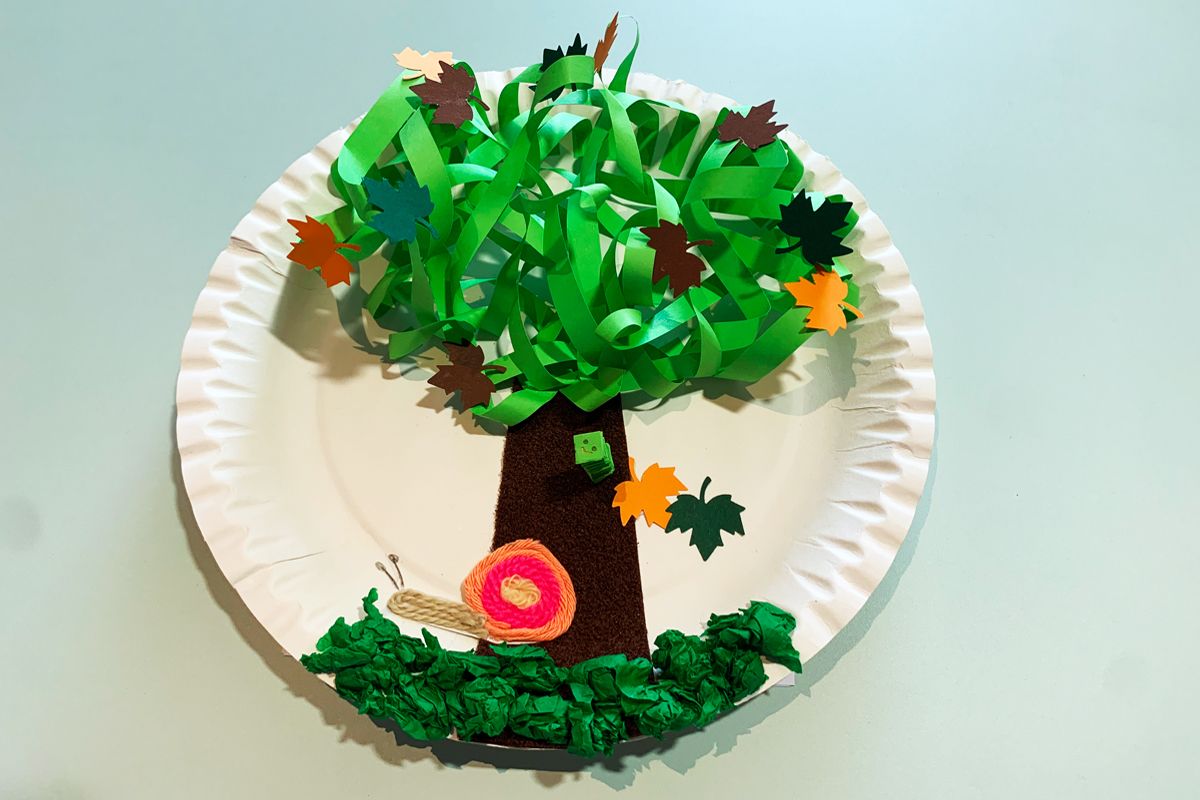 Herbstferienprogramm 3-D-Baum Aus gerollten und geknüllten Papierstreifen gebildeter Baum mit Gras und Tieren.