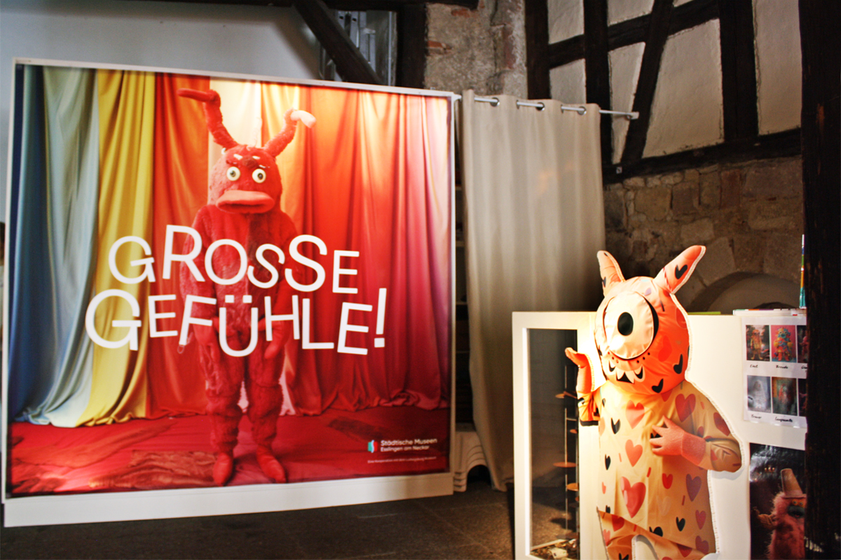 Großes Bild mit einer Figur und dem Ausstellungstitel Große Gefühle. 