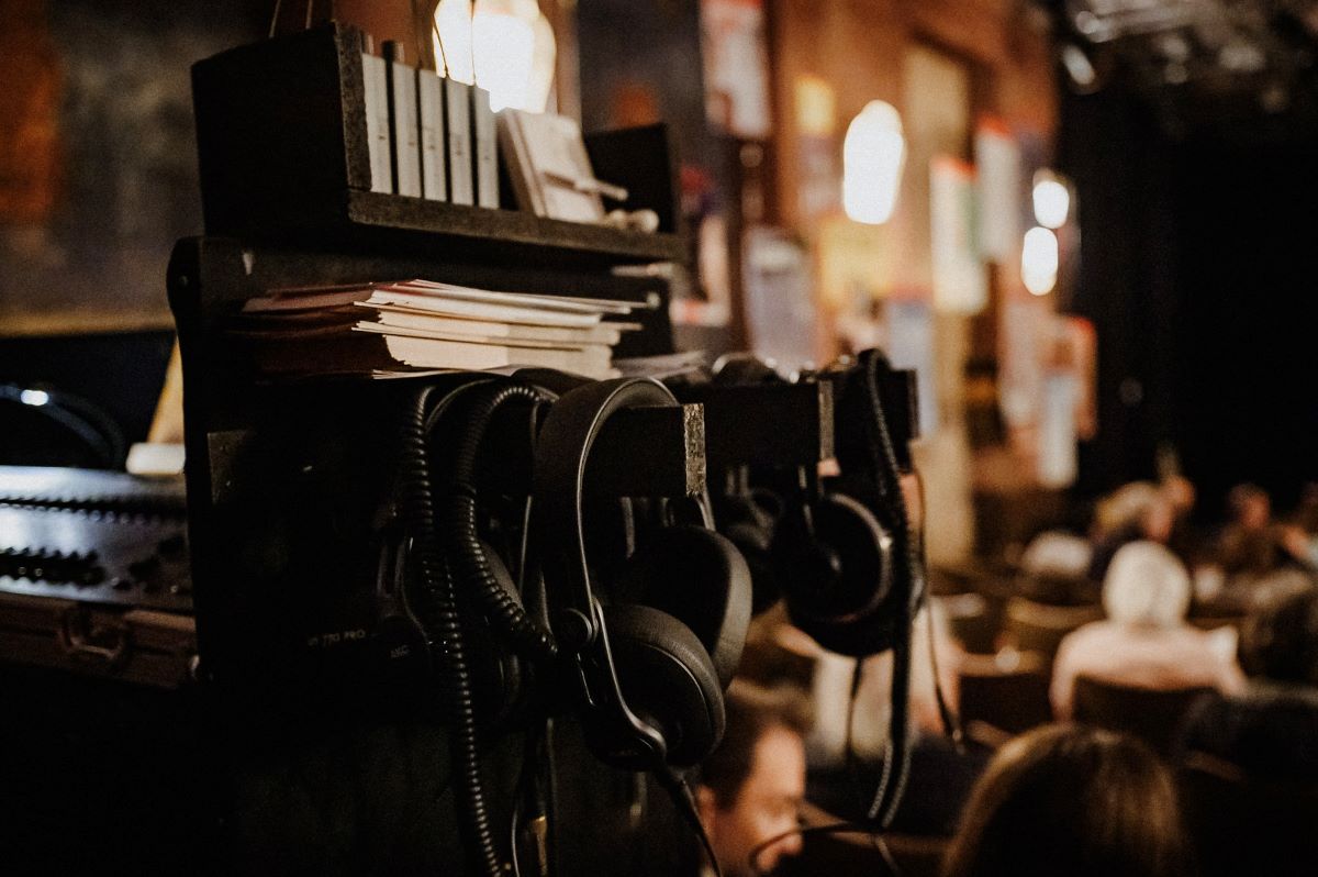 SiF2024 Kunstdruck CentralTheater © Sabine Watzko Kopfhörer hängen an einem Technikpult in einem Theatersaal