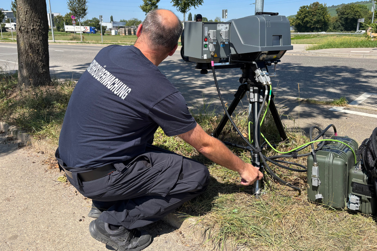 Mobiler Blitzer Kollege kniet vor Kamera